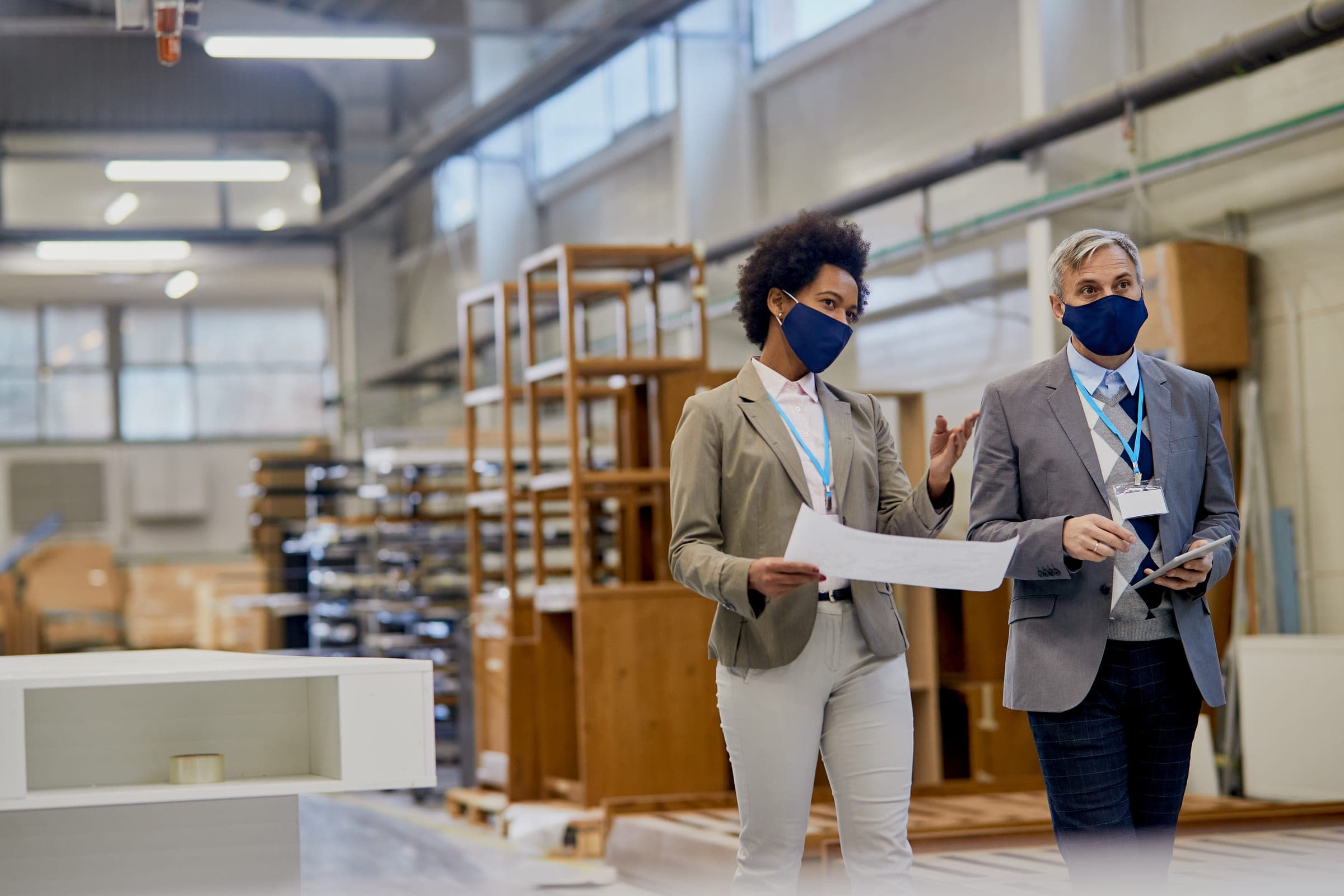 Two professionals discussing industrial special risks in a commercial warehouse.