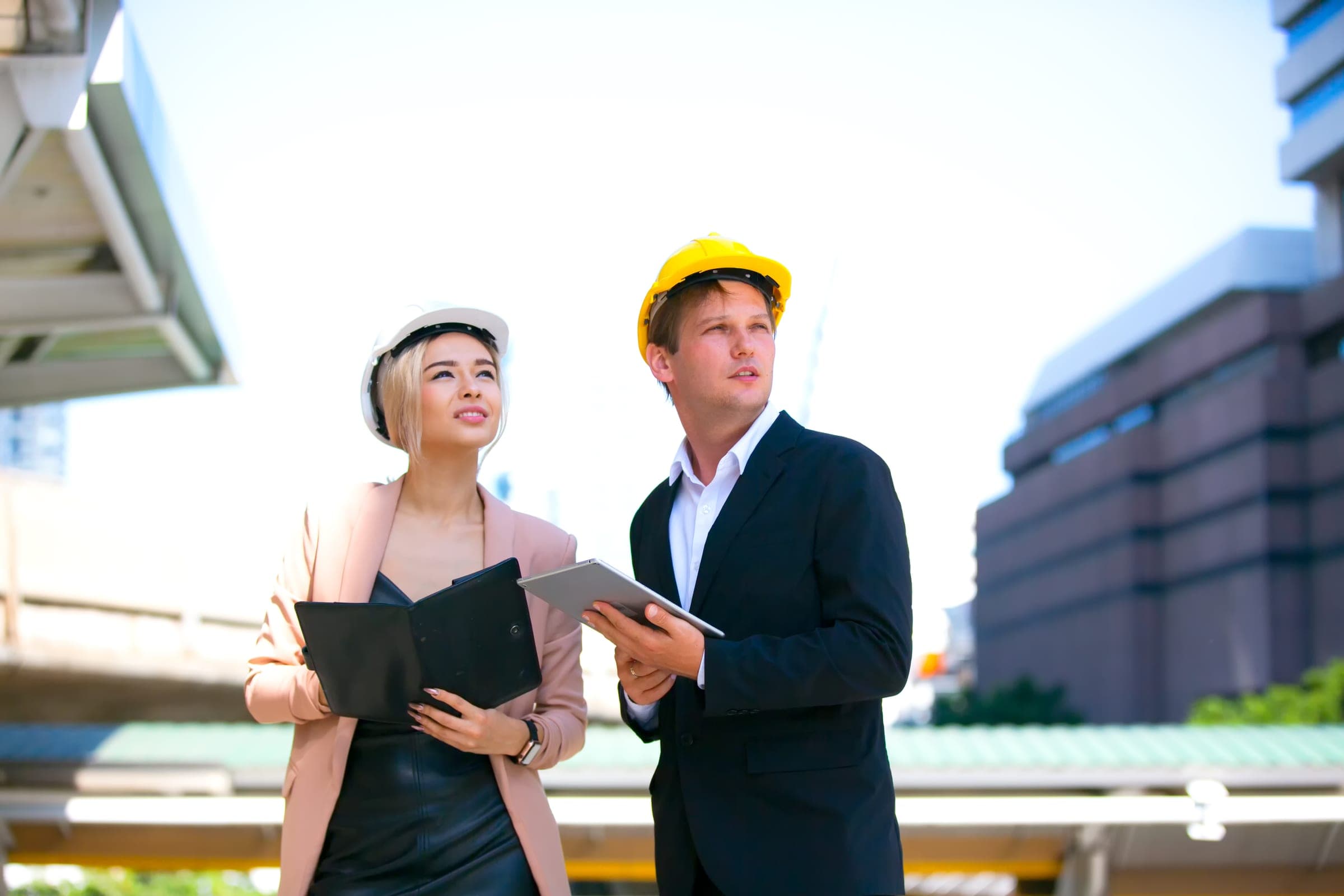 Engineers Discussing Insurance Needs Two engineers in Queensland discussing professional indemnity cover outdoors.