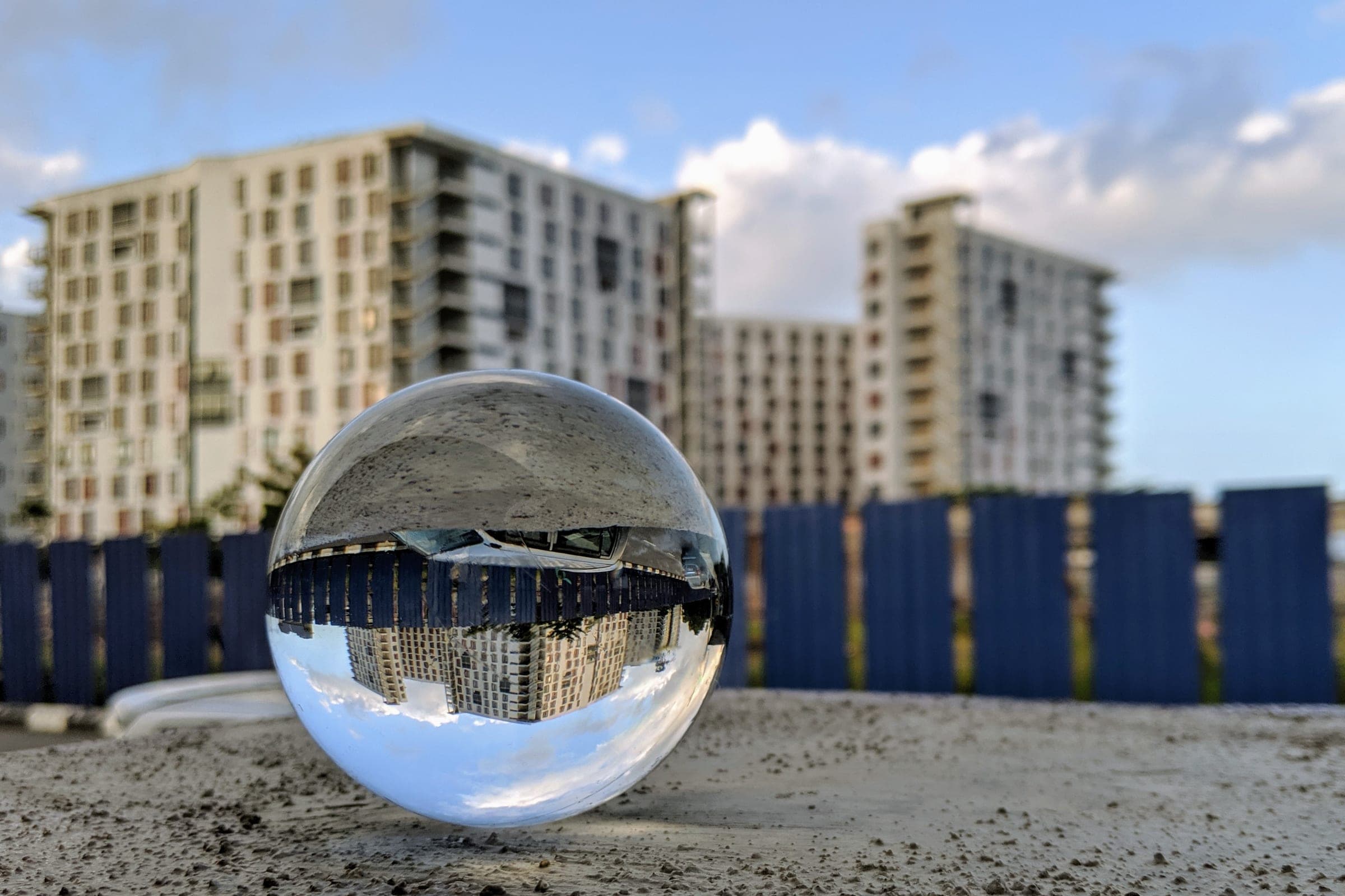 Upside-down view of Gold Coast buildings through a glass sphere, highlighting strata property insurance issues.