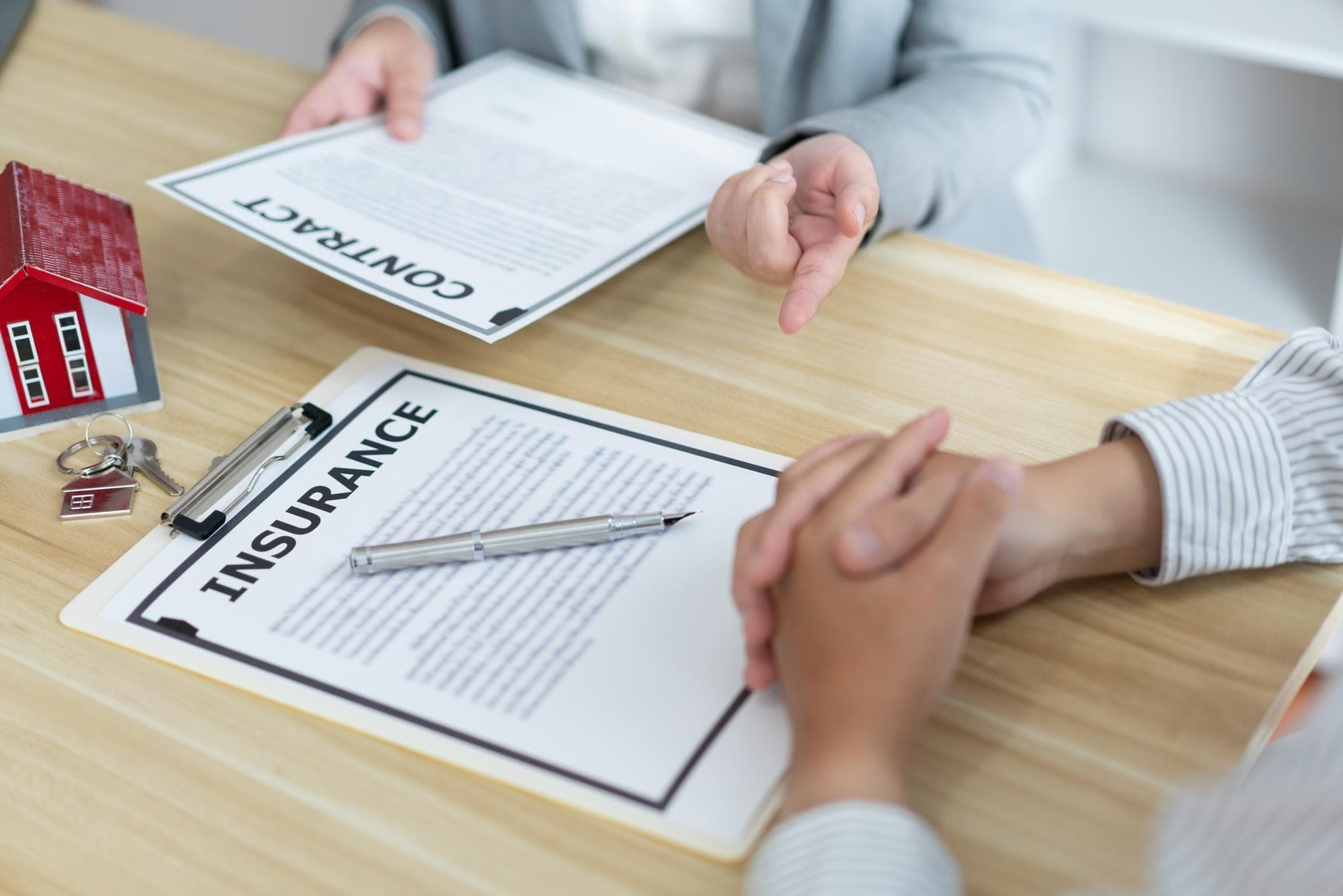 Two professionals review insurance documents at a desk.