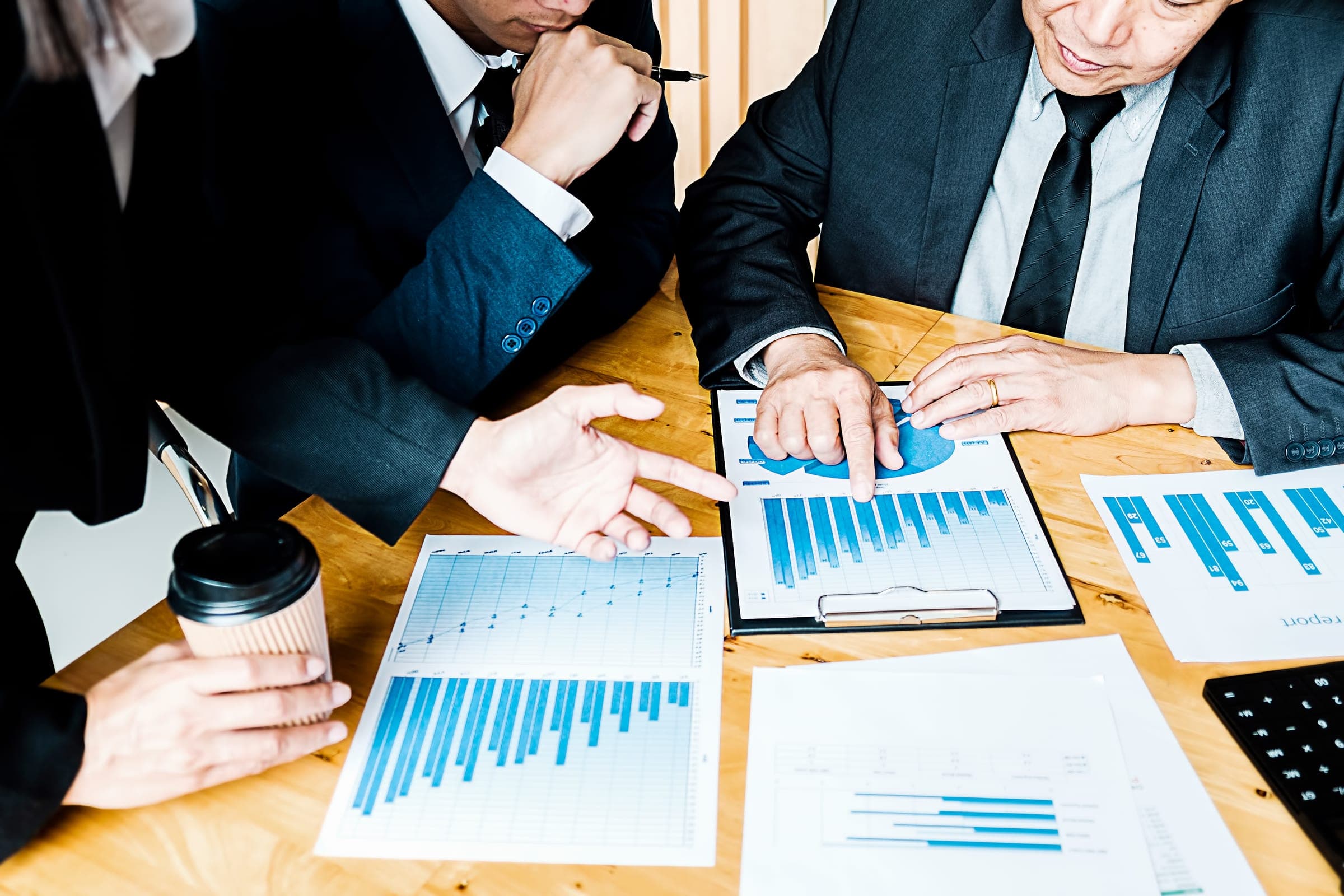 Business team discussing management liability over charts.